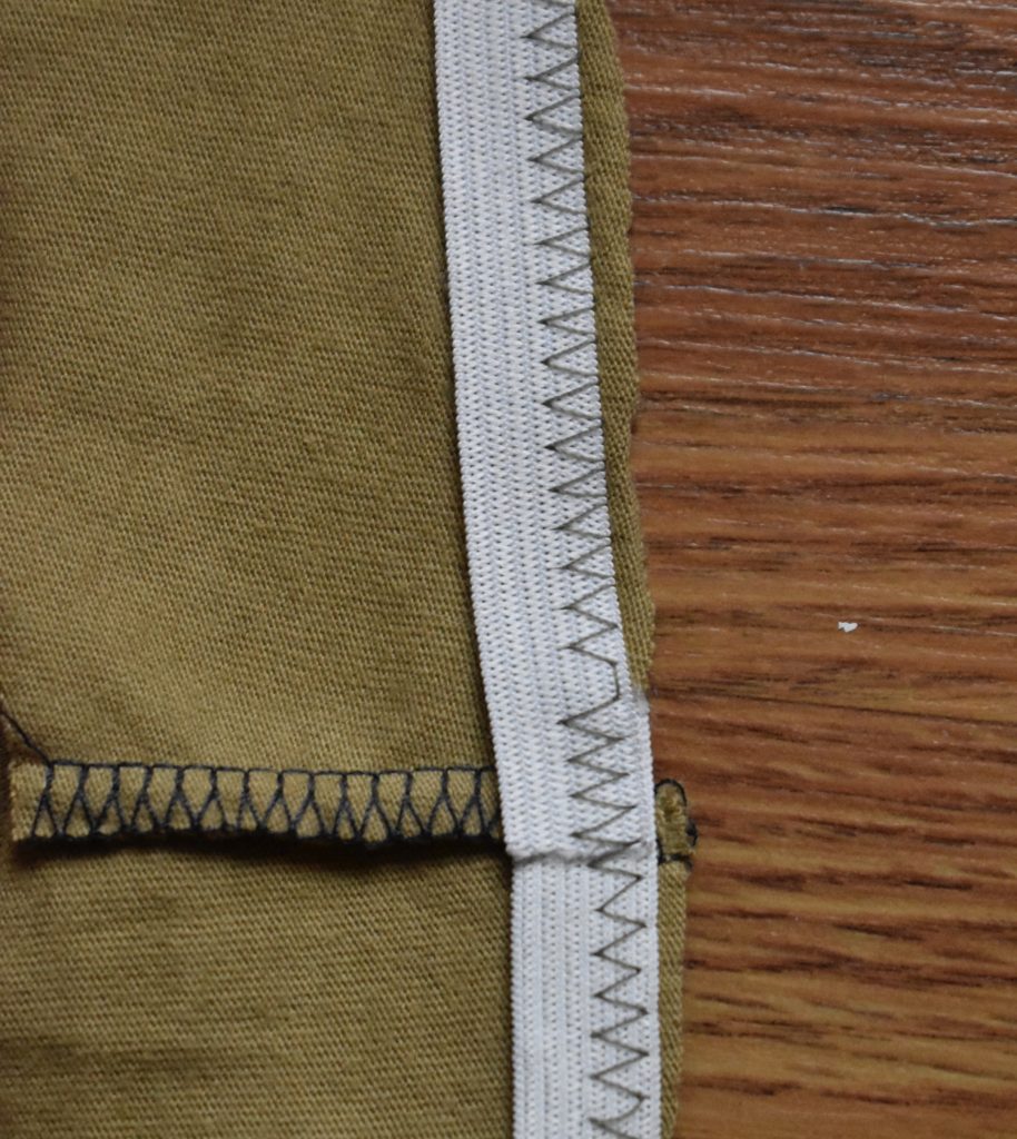 Elastic attached to bottom hem of internal tank piece with a zigzag stitch.